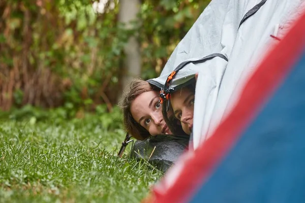 Дождь падает на палатки, девушки подглядывают — стоковое фото