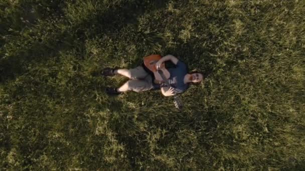 Игра на гитаре в траве, вид с воздуха — стоковое видео