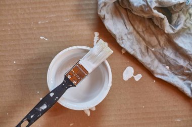 Beyaz duvar boyası kutusunda boya fırçası