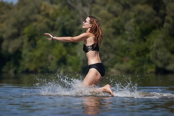 Ragazza in spiaggia che corre in acqua — Foto Stock