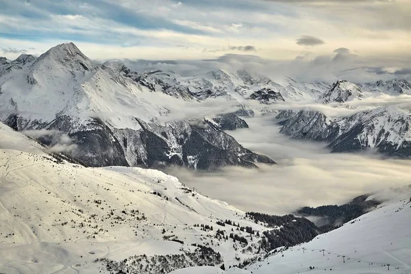 Горный зимний пейзаж над облаками — стоковое фото