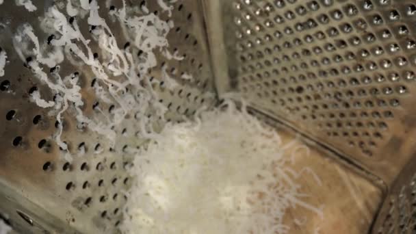 Grating cheese perspective from inside the grater — Stock Video