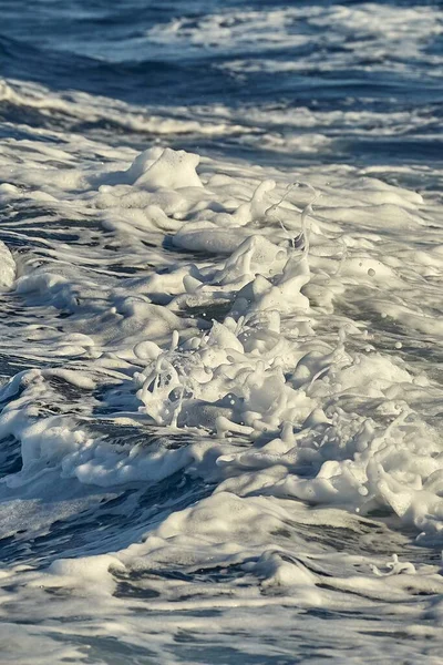 Vlny s pěnou stříkající v mořské vodě — Stock fotografie