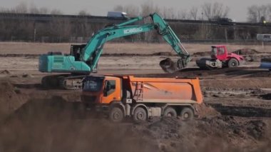 Budapeşte, Macaristan - 2022 civarı: Toprak, güçlü ısı sisi ve tozla dolu bir yol şantiyesine çöp kamyonu