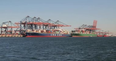 Rotterdam, Hollanda - 2019 dolaylarında Rotterdam Limanı 'nın Euromax konteyner terminalindeki büyük bir kargo gemisine yüklenen konteynırlar, gantry vinçleri, büyük konteynır gemileri