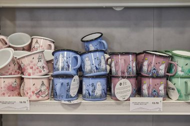Ivalo, Finlandiya - 2022 civarı: Moomin temalı kupalar havaalanı hediyelik eşya dükkanında satılıyor. Fin çocuk kitapları ve çizgi filmlerinin popüler karakterleri, moomin ailesinin üyeleri.