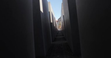 Berlin 'deki Yahudi Soykırımı anıtı, beton levhalar arasında dönen kamera.