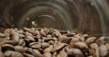 Coffee beans in a jar toppled over, probe lens weird perspective macro inside the glass, slow, smooth camera motion