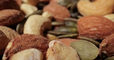 Fındık ve tohumlar makro kamera hareket dürbünü lenslerini yığıyor. Kaju, badem ve balkabağı tohumu
