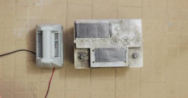 Bir araba marş bataryasını şarj etmek, şarj etmek için elektrik terminallerine kablo bağlamak.
