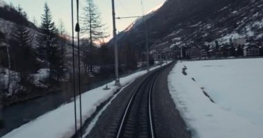 İsviçre Alpleri 'ndeki Zermatt hattında tren yolculuğu, sürücülerin karlı kış akşamlarında Matterhorn eteklerindeki dağlık kasabaya bakış açısı.