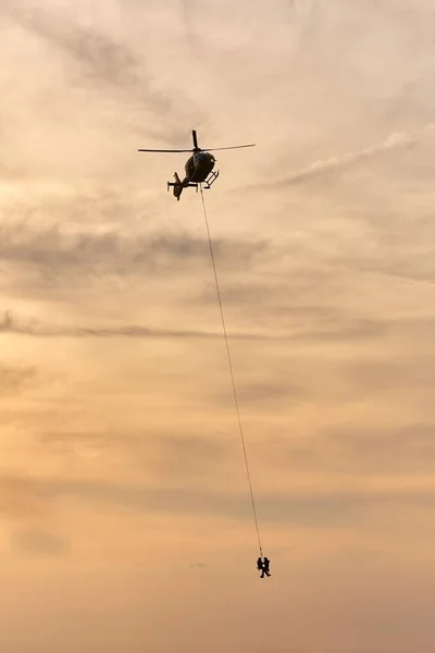 Rettungshubschrauber Fliegt Mit Menschen Die Einem Seil Hängen — Stockfoto