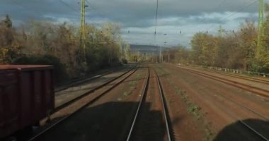Tren yolculuğu bakış açısı son vagonun arkasından, petrol için yük arabalarıyla endüstriyel bölgelerden geçiyor.