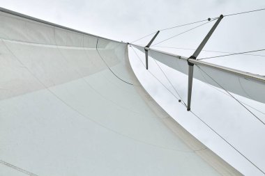 Sailing boat sail and mast detail against cloudy sky