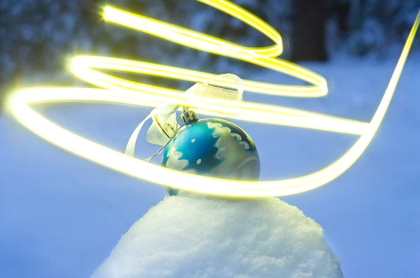 Urlaubsstimmung mit Ball auf Schnee im dunklen Park — Stockfoto