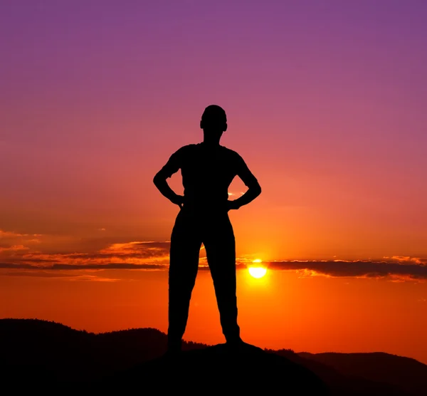 Silhouette di giovane uomo in montagna al tramonto — Foto Stock