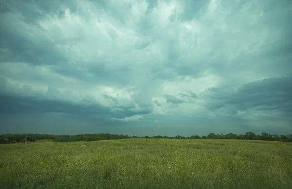 Nuvole di tempesta con pioggia sul prato con erba verde — Foto Stock