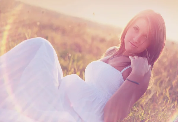 Woman sitting in a field. Looking at camera — Stock Photo, Image