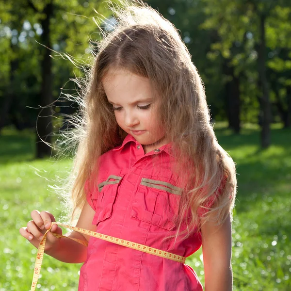 Klein meisje haar taille meten — Stockfoto