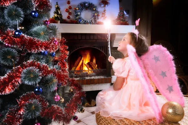 Liten älva tjej med trollspö nära en julgran — Stockfoto