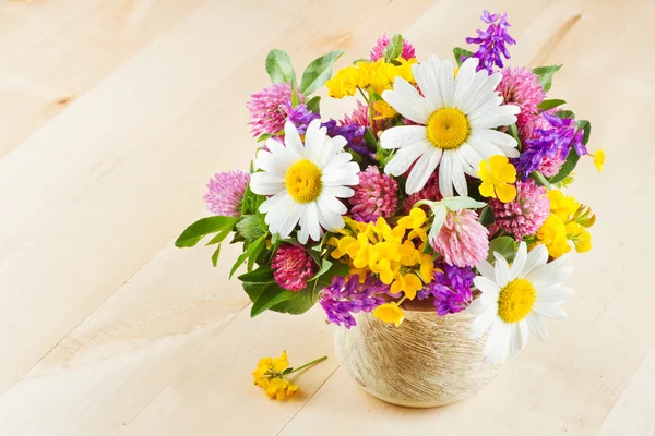 Florero con ramo de flores y hierbas curativas sobre mesa de madera —  Fotos de Stock