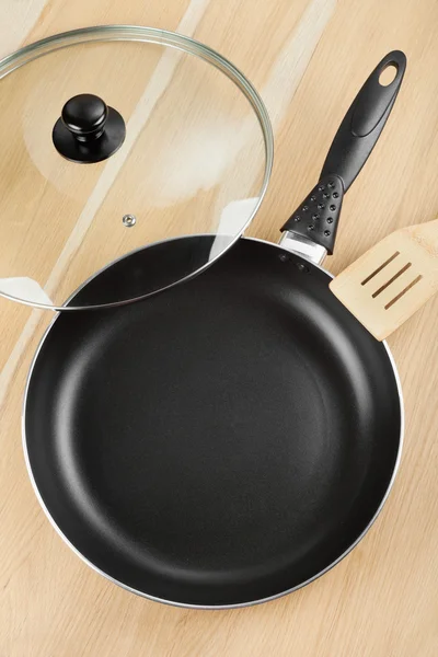 Frying pan with lid on wooden table — Stock Photo, Image