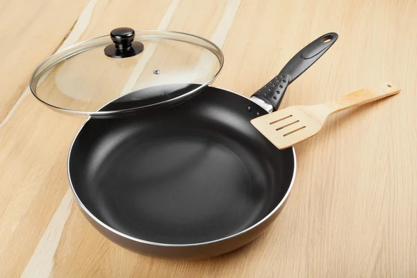 Frying pan with lid on wooden table — Stock Photo, Image