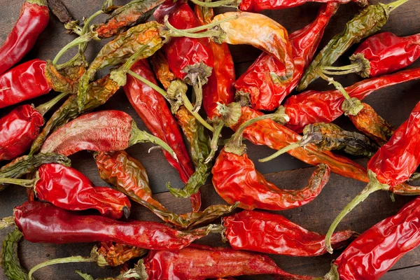 Red chili peppers on wooden table — Stock Photo, Image