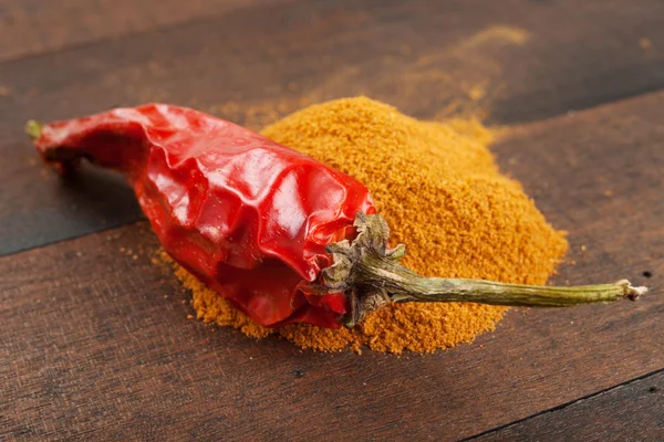 Red chili pepper and pile of ground chilly — Stock Photo, Image