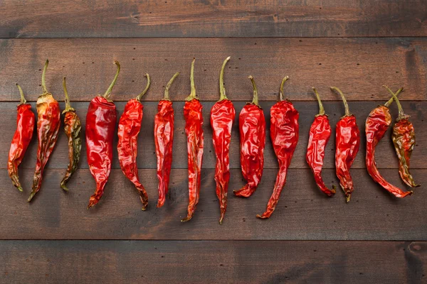 Red chili peppers on wooden table — Stock Photo, Image