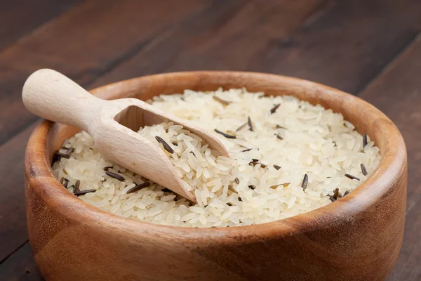 Bílá a divoká rýže v dřevěné misce na kuchyňském stole — Stock fotografie