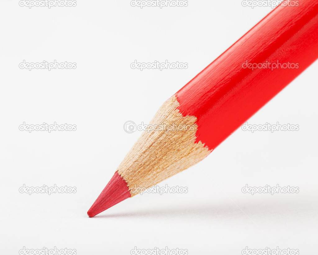 red pencil draws or writing on white paper sheet