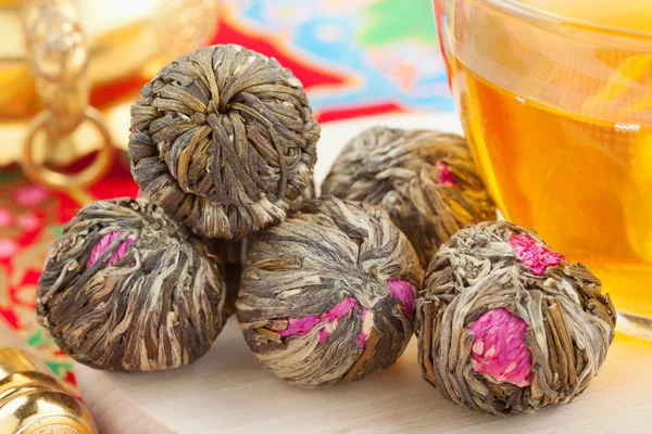 Boules de thé vert chinois avec des fleurs, tasse de thé — Photo