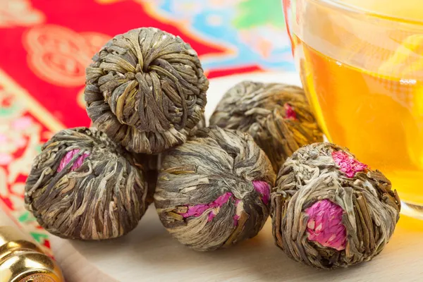 Boules de thé vert chinois avec des fleurs, tasse de thé — Photo