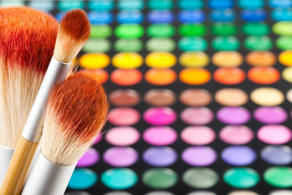 Make up borstels en als achtergrond instellen van kleurrijke eye shadows — Stockfoto