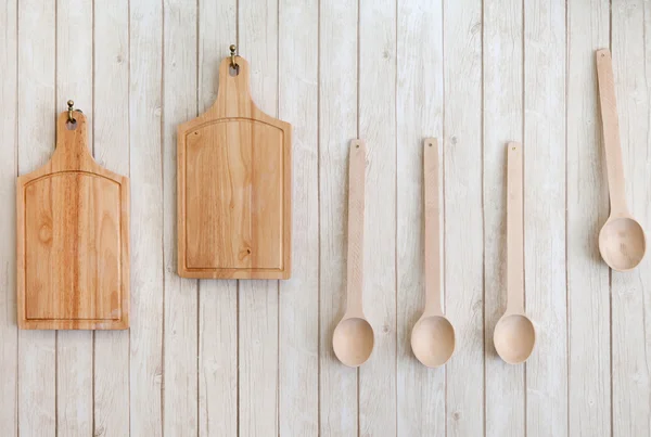 Cutting boards and wooden spoons hanging on the wall — Stock Photo, Image