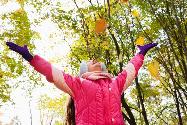 Happy little girl with hands up in autumn park — Stock Photo, Image