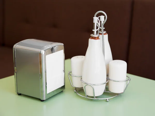 Pepper and salt shakers, bottles for oil and vinegar, napkin holder - cafe table top set — Stock Photo, Image