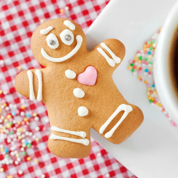 Gingerbread man and coffee cup on table — Stock Photo, Image