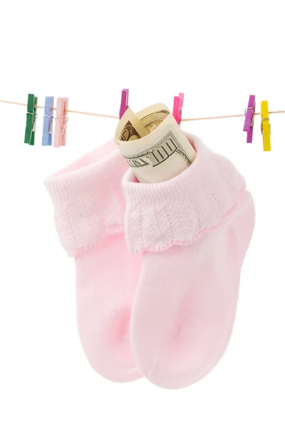 Peníze v ponožce na prádlo linie s růžovými kolíčky na prádlo, izolovat d na — Stock fotografie