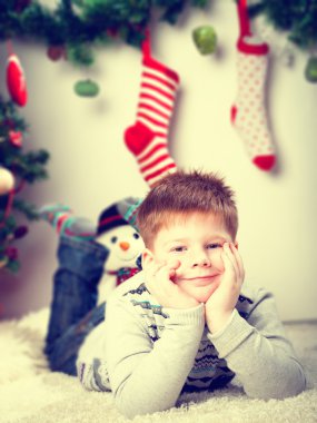 mutlu Noel ağacının yakınında küçük çocuk gülümseyen