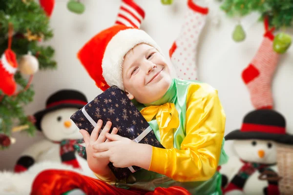 Menino sorridente feliz com caixas de presente de Natal perto do Chri — Fotografia de Stock