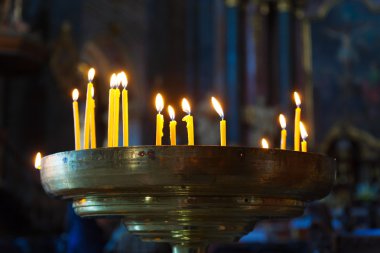 Kilise, karanlık bir odada birkaç uzun boylu mumlar yaktı