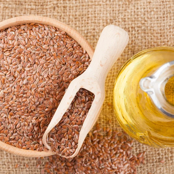 Mortar with flax seeds and linseed oil in glass jug — Stock Photo, Image