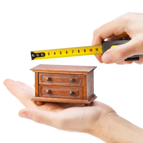 Woodworker measuring chest of drawers with a tape measure, carpe — Stock Photo, Image