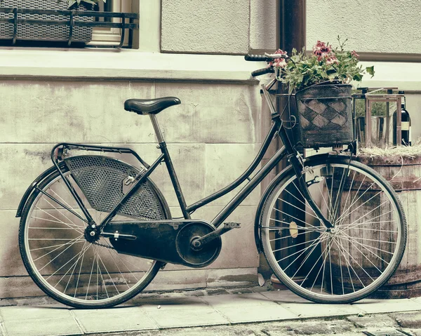 Vintage stylized photo of Old bicycle carrying flowers — Stock Photo, Image