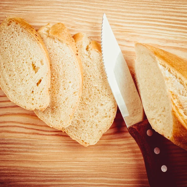 Baguette recién cortada en rodajas sobre tabla de cortar de madera —  Fotos de Stock