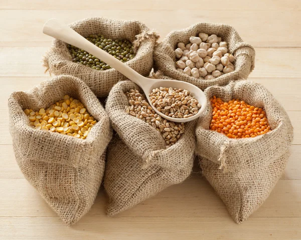 Hessian bags with peas, chick peas, red lentils, wheat and green — Stock Photo, Image