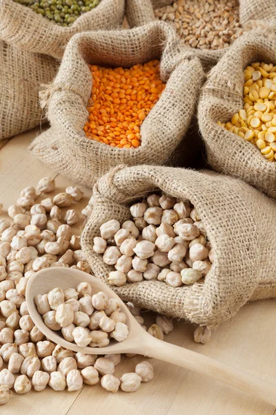 Hessian bag with chickpeas and sack with grains — Stock Photo, Image