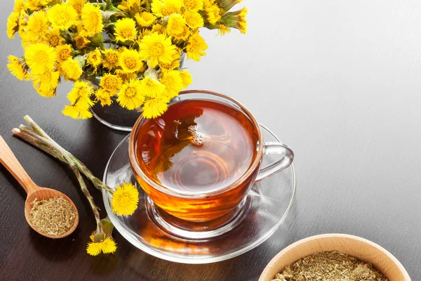 Healthy tea closeup, bucket with coltsfoot flower — Stock Photo, Image
